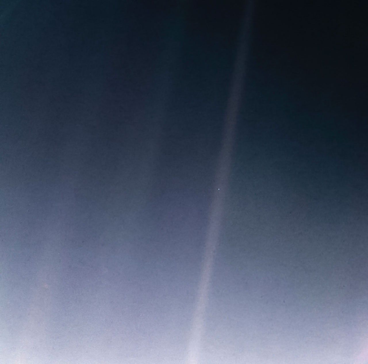 The Pale Blue Dot: Earth as a single bright speck in a band of scattered sunlight, photographed by Voyager 1.